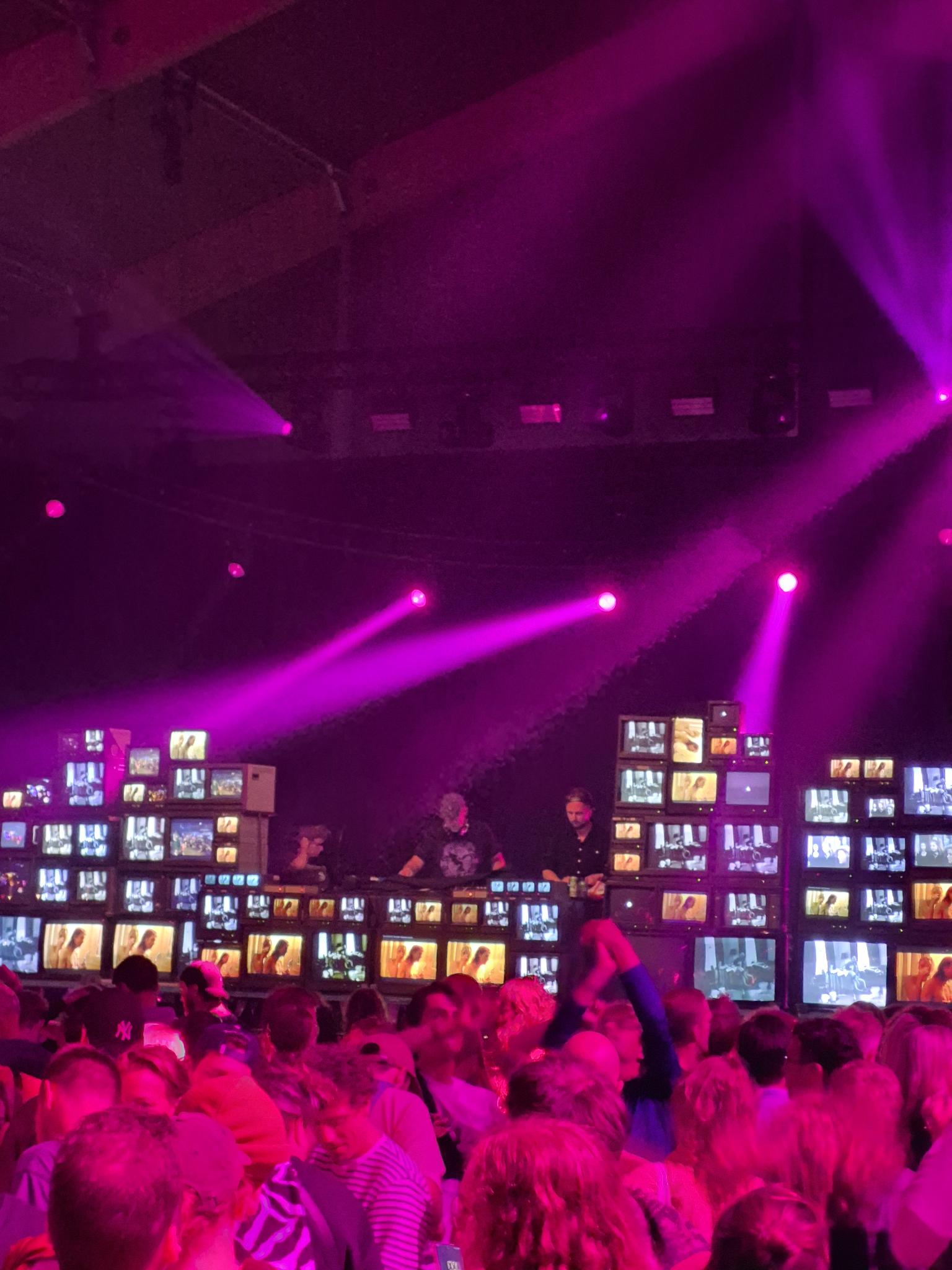 Publiek voor de videowall met dj's op het podium in de Lima tent