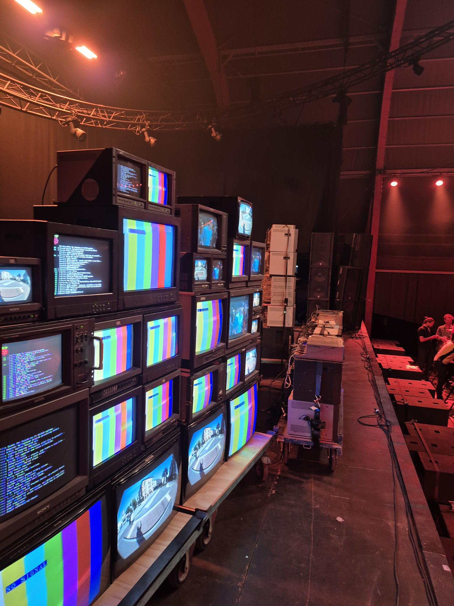 Detail van de opgestapelde tv's in de videowall op Lowlands